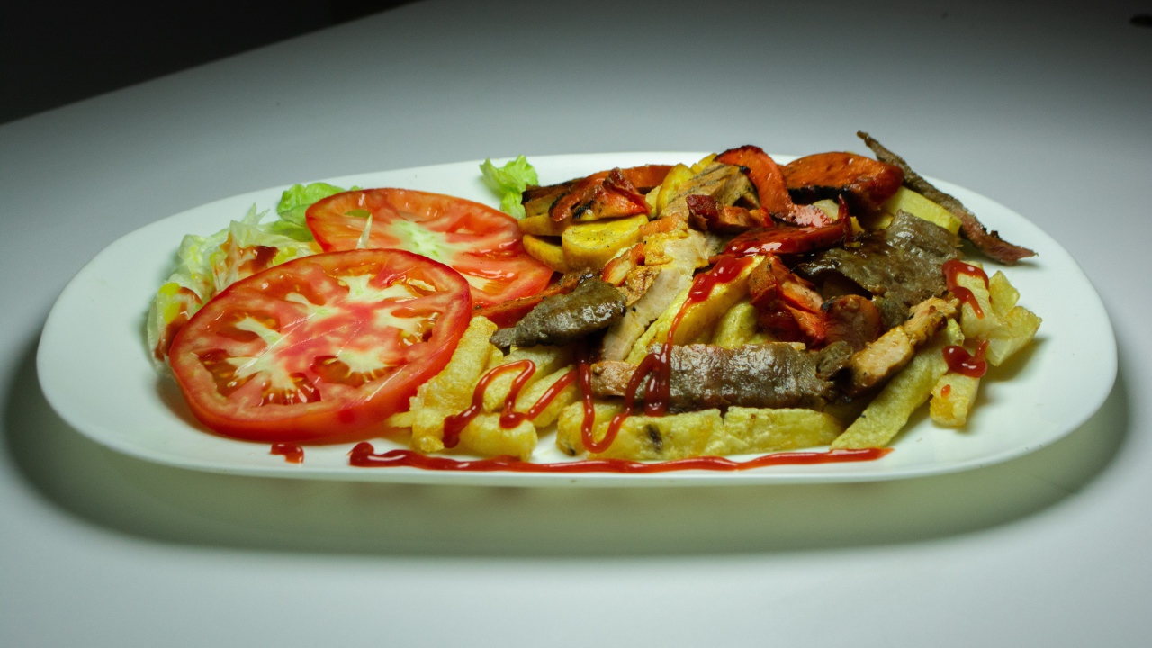 Картофель фри на тарелке с помидорами 