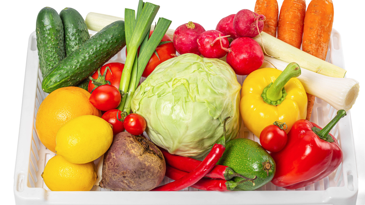 Свежие аппетитные овощи в ящике на белом фоне