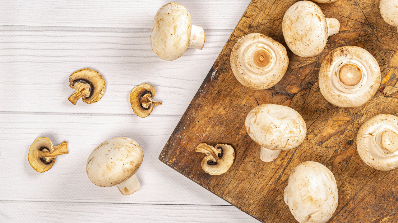Свежие шампиньоны на разделочной доске