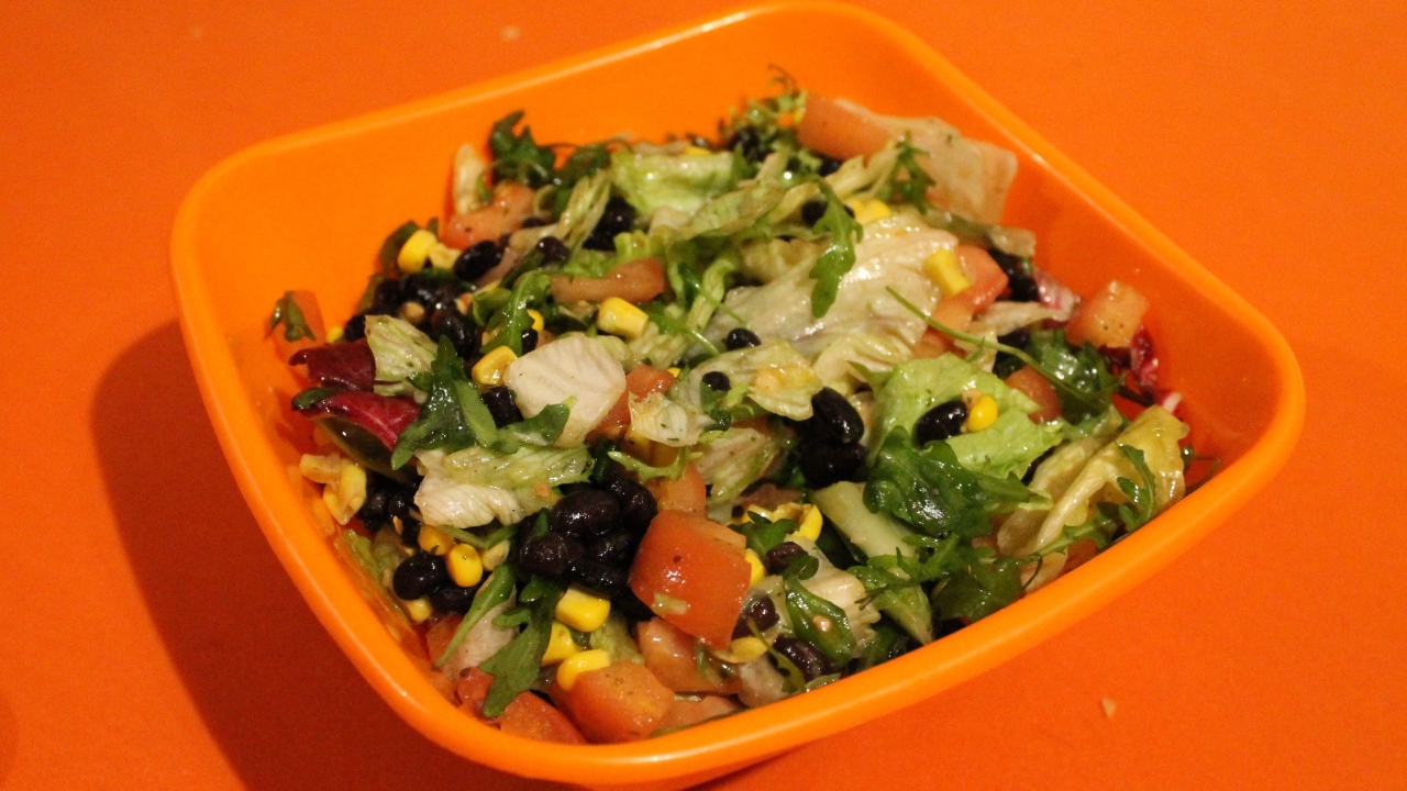 Салат из свежих овощей на оранжевом фоне