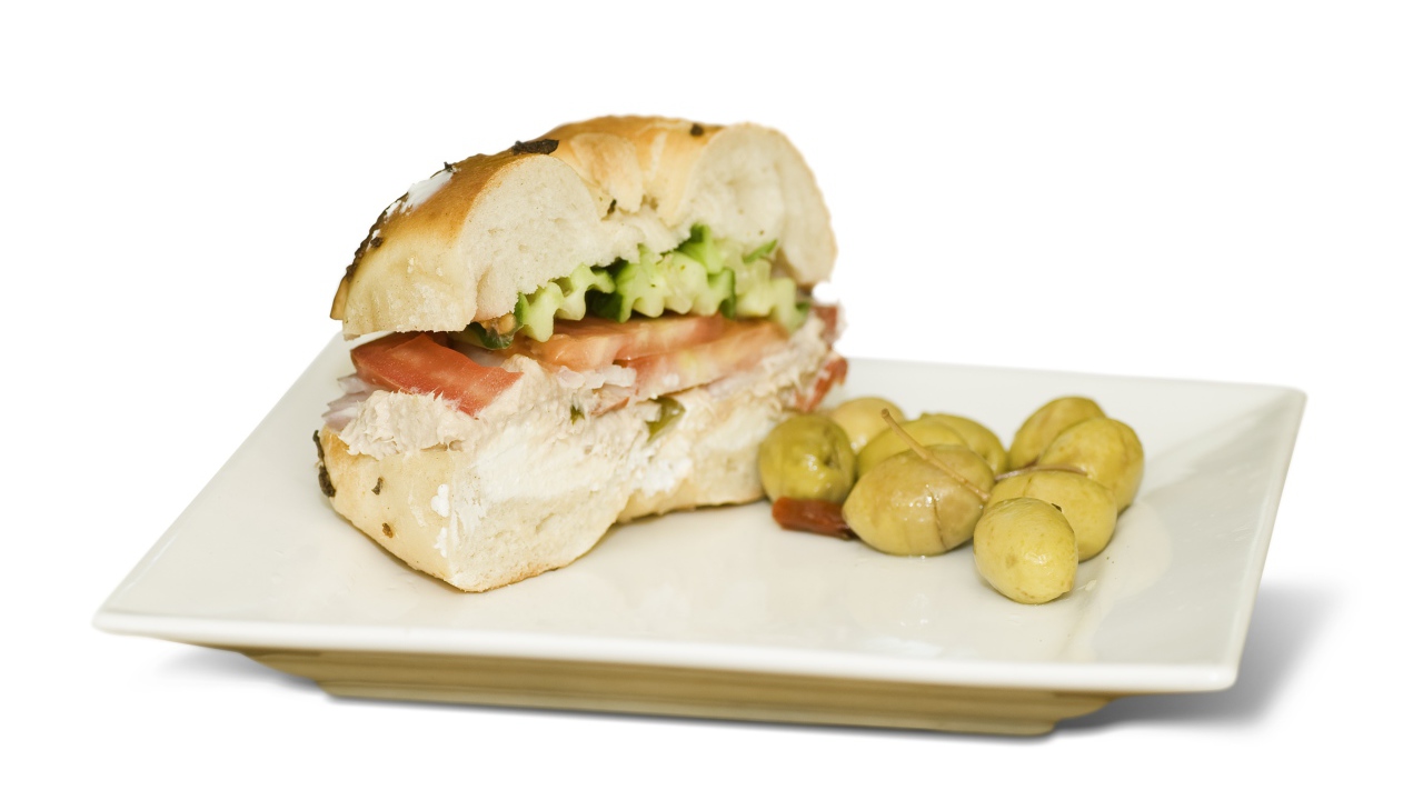 Половина гамбургера на тарелке с оливками