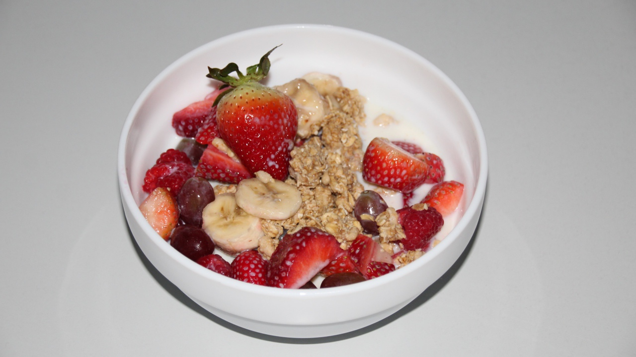 Мюсли с молоком и ягодами на сером столе