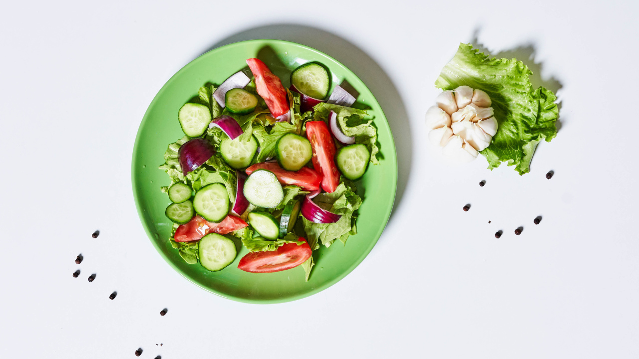 Салат с огурцами, луком, помидорами и листьями салата
