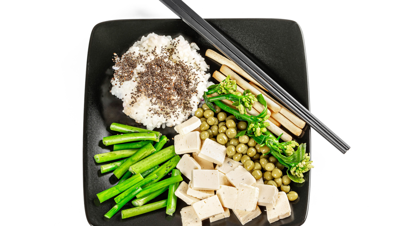 Овощи, сыр и рис на тарелке с палочками