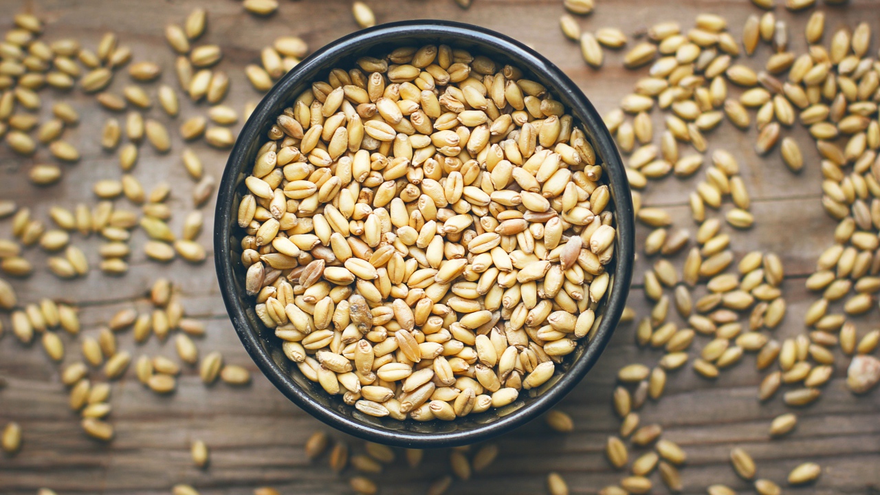 Зерна пшеницы в черной кружке на столе 