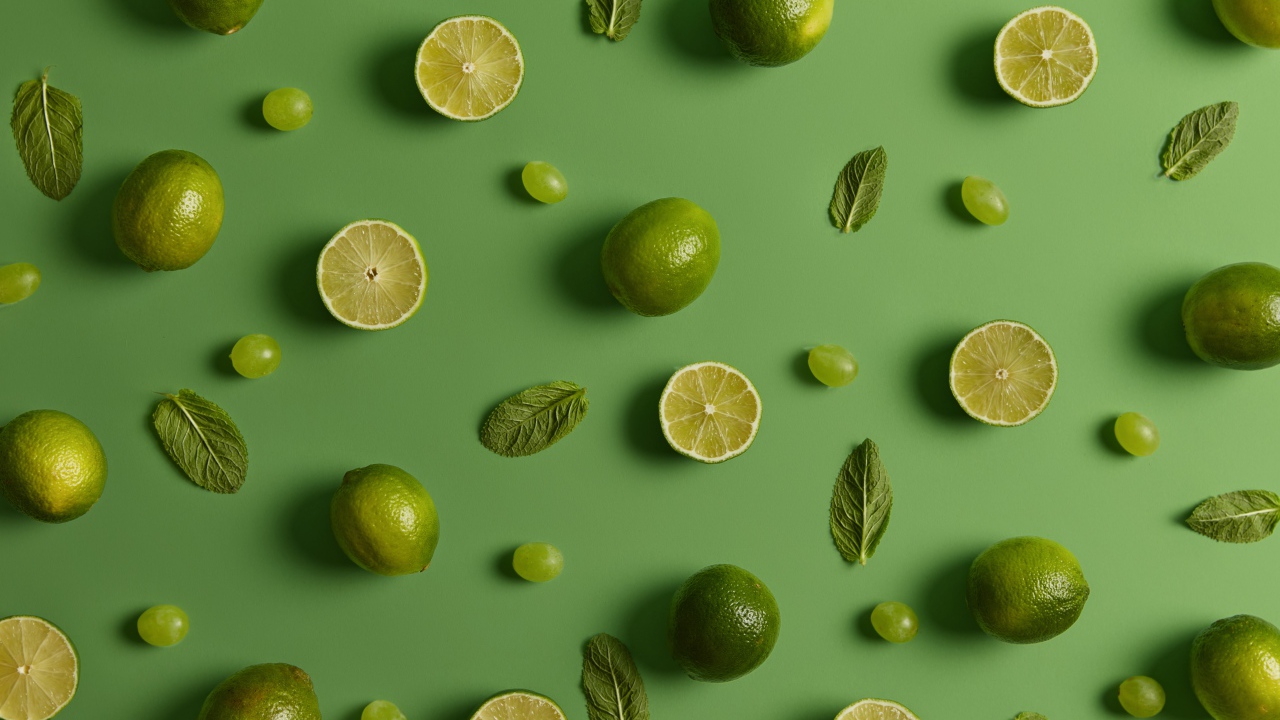 Лимоны и лаймы на зеленом фоне