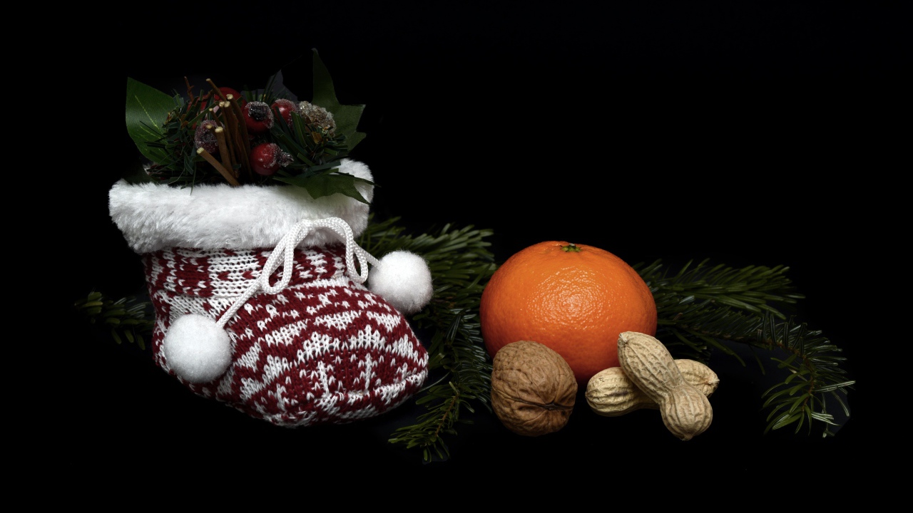 Мандарин с орехами и украшениями на черном фоне 