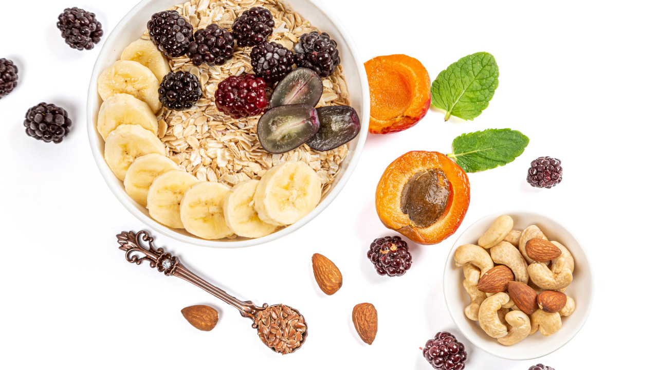 Овсяные хлопья с ягодами и орехами на белом фоне