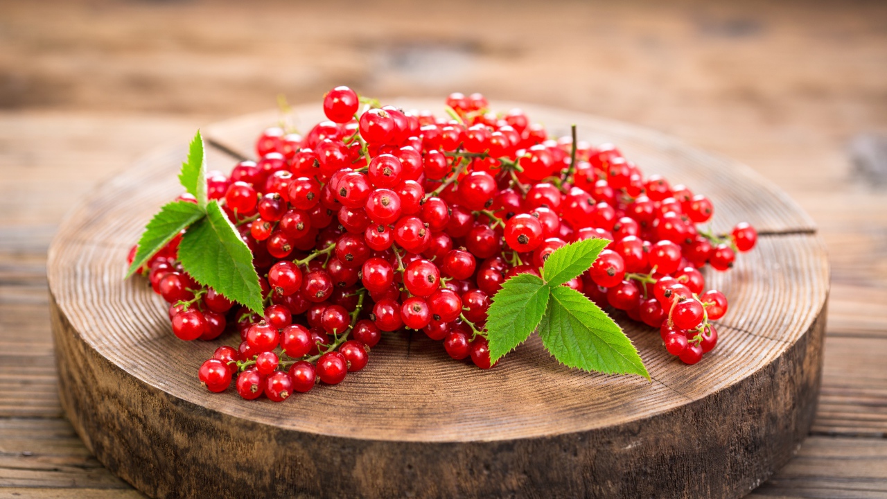 Спелая красная смородина на деревянной доске