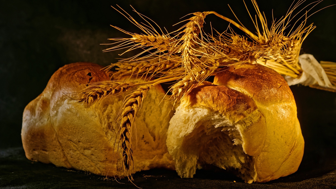 Свежий хлеб с колосьями пшеницы на столе
