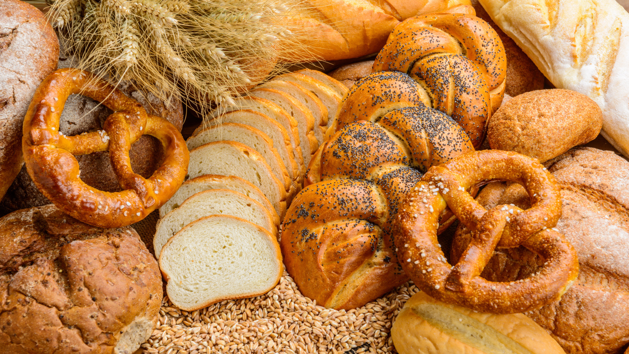 Свежая выпечка на столе с колосьями и зернами пшеницы 