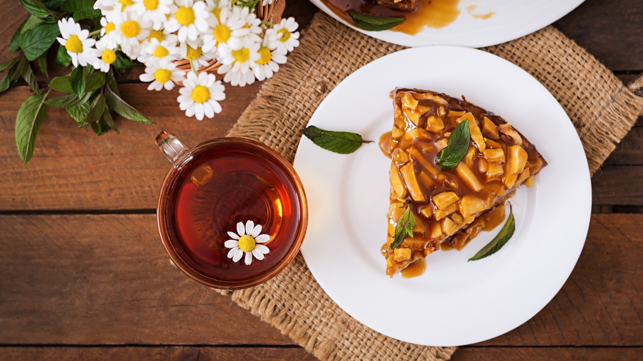 Кружка ромашкового чая на столе с куском пирога