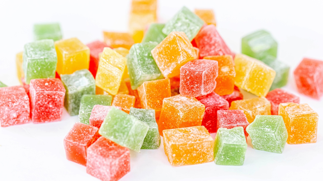 Аппетитный разноцветный мармелад в сахаре на белом фоне 