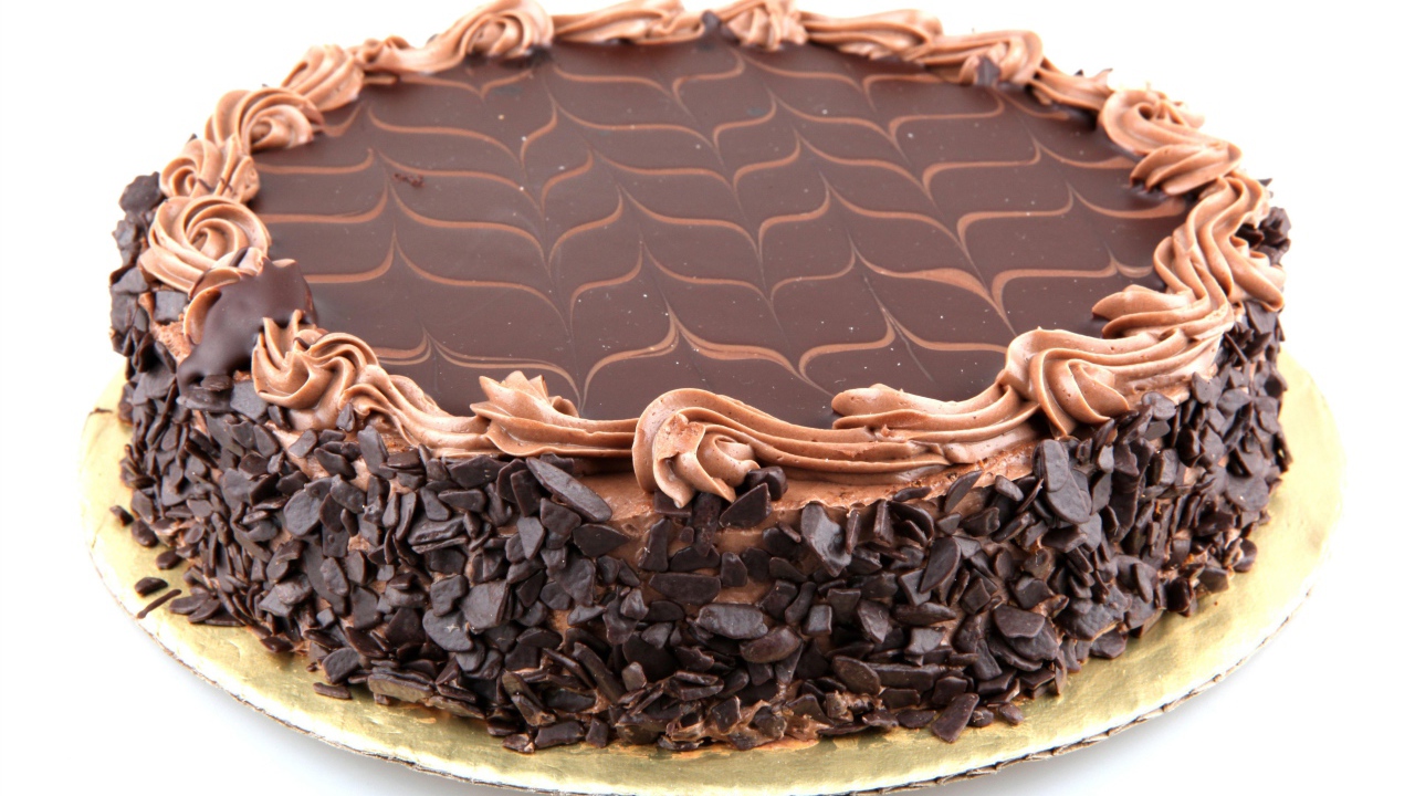 Большой праздничный торт с шоколадной крошкой на белом фоне