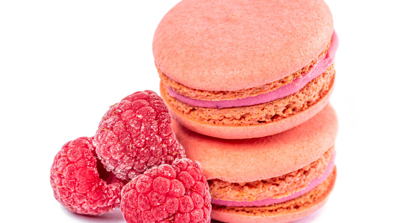 Десерт макарон с малиной на белом фоне