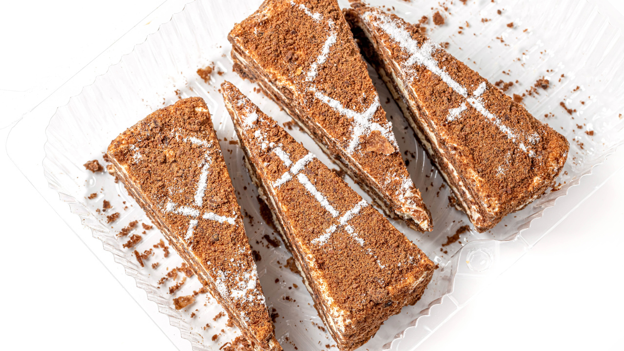 Куски аппетитного медового торта на белом фоне