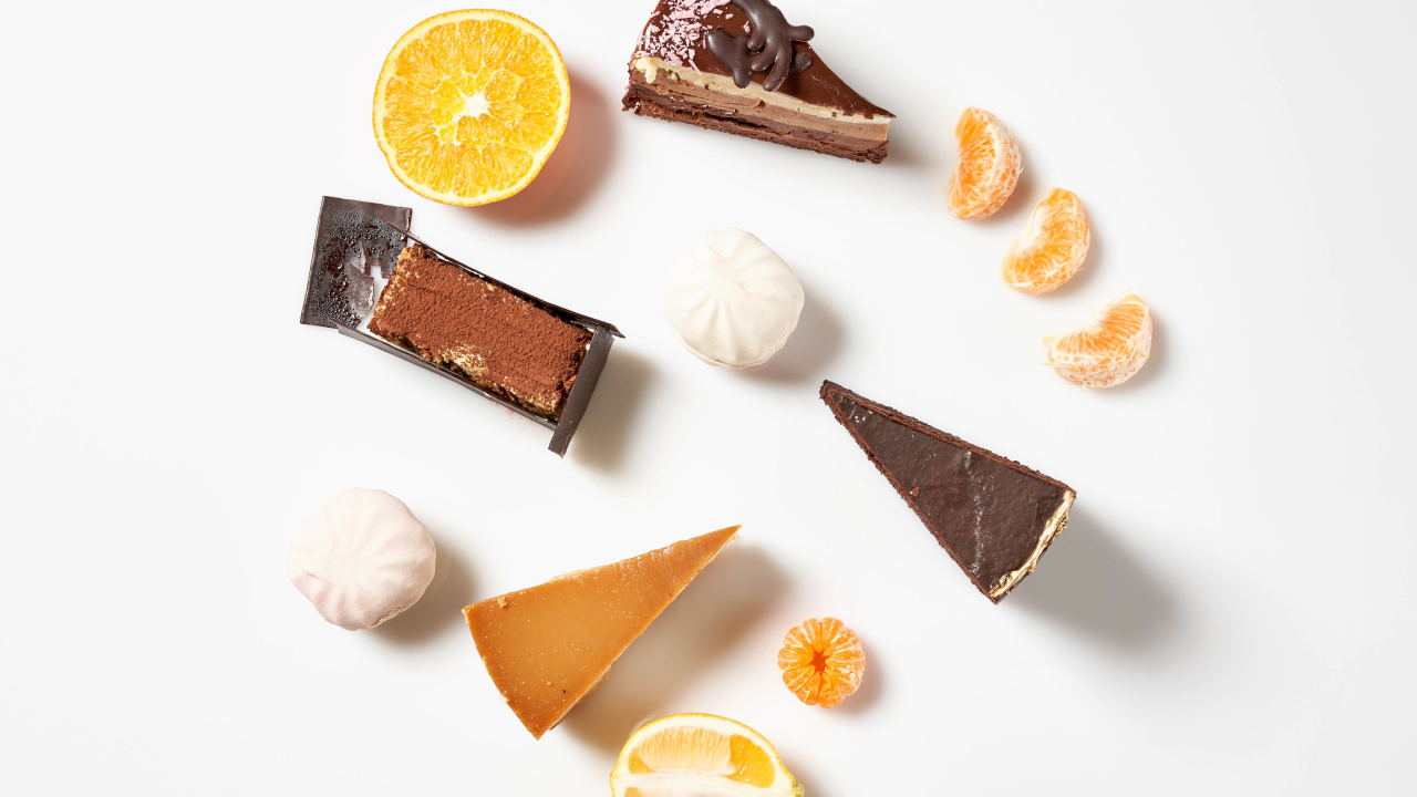 Куски торта на белом фоне с мандарином и лимоном