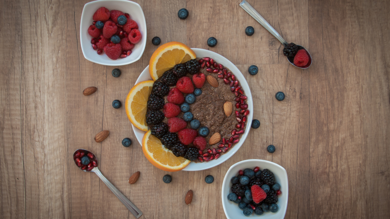 Каша с ягодами в тарелке на столе на завтрак