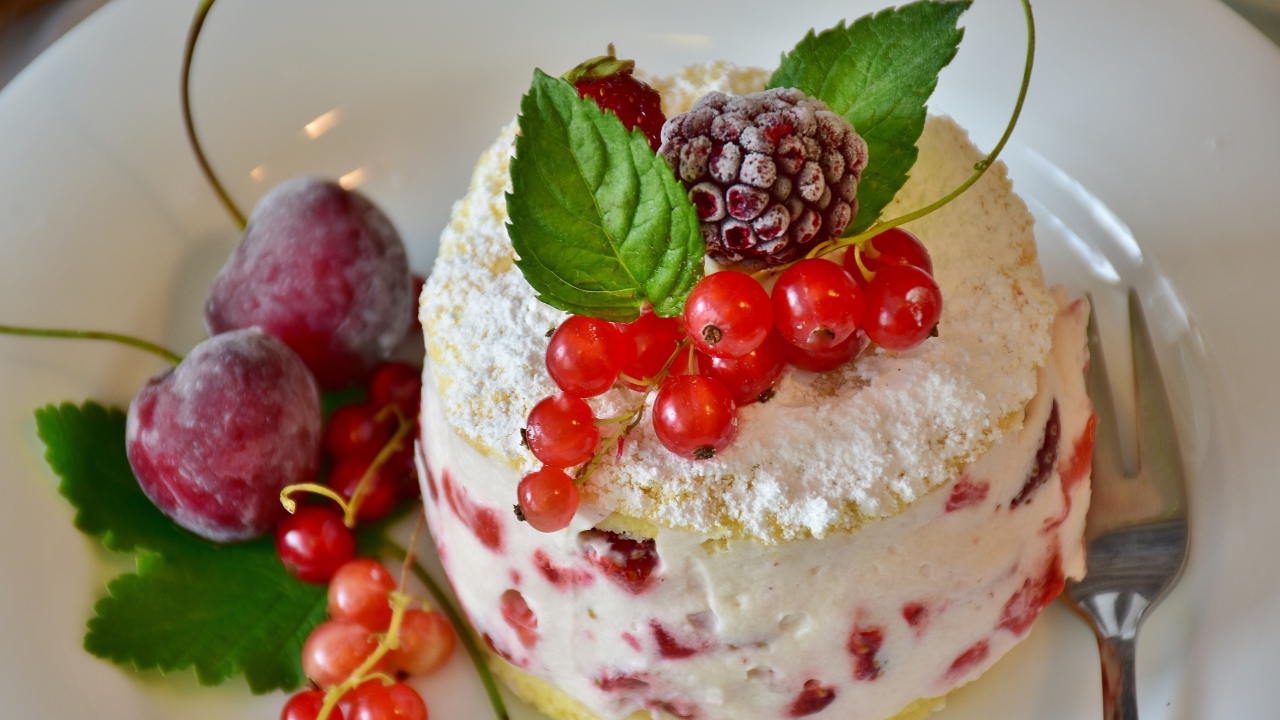 Пирожное со взбитыми сливками украшено ягодами