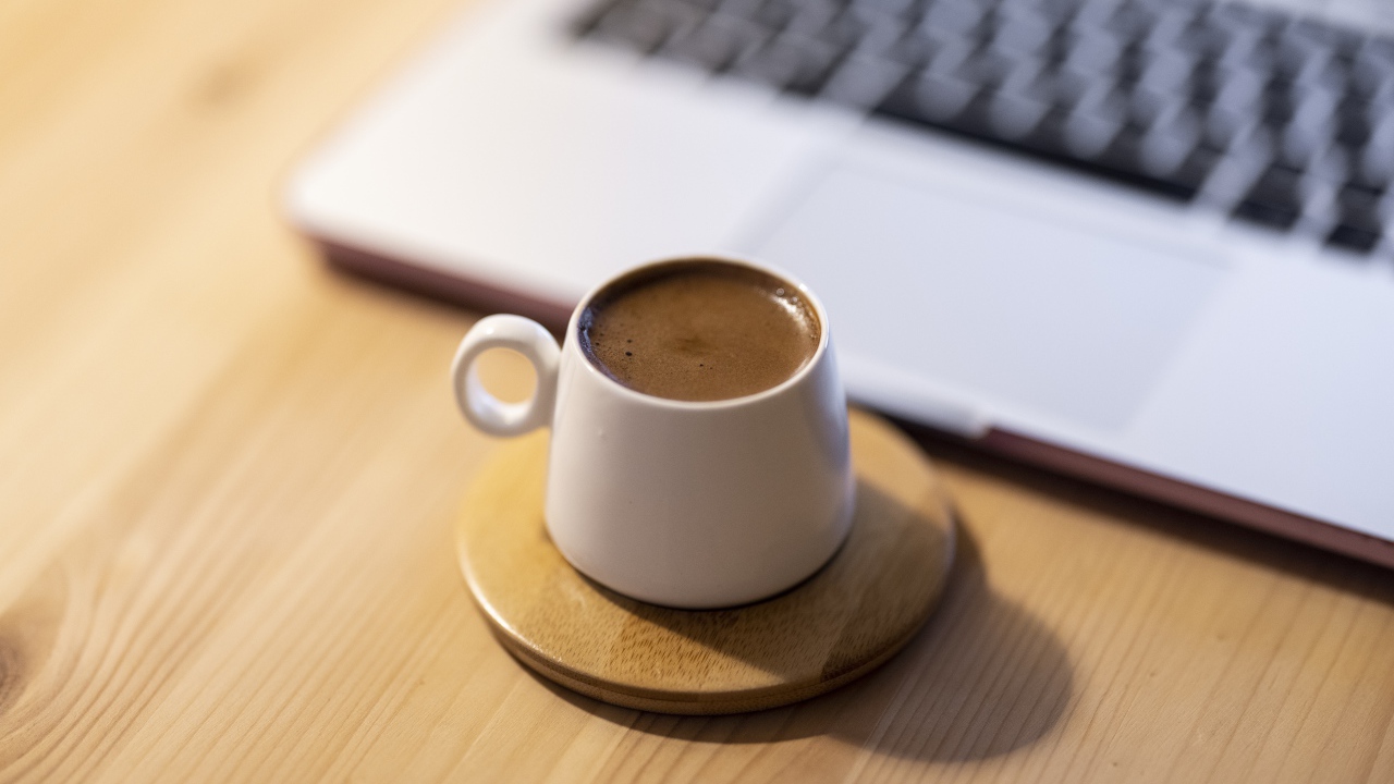 Чашка кофе стоит у ноутбука 