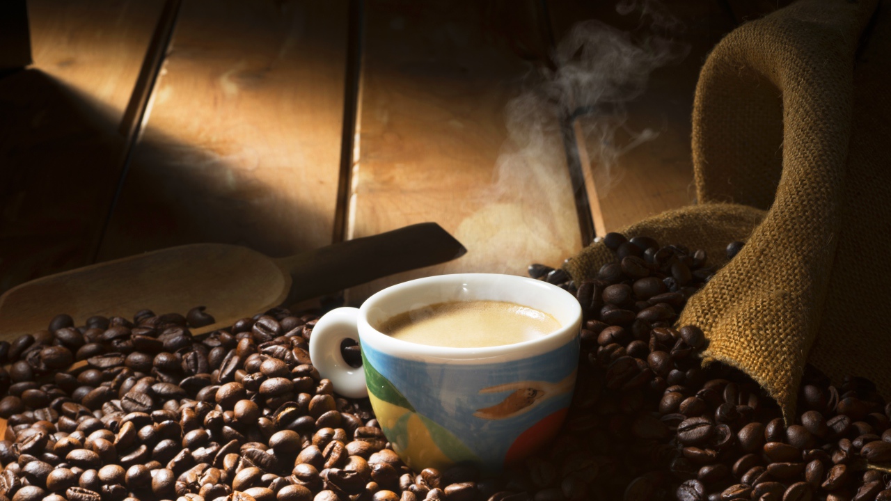 Чашка горячего кофе стоит на зернах