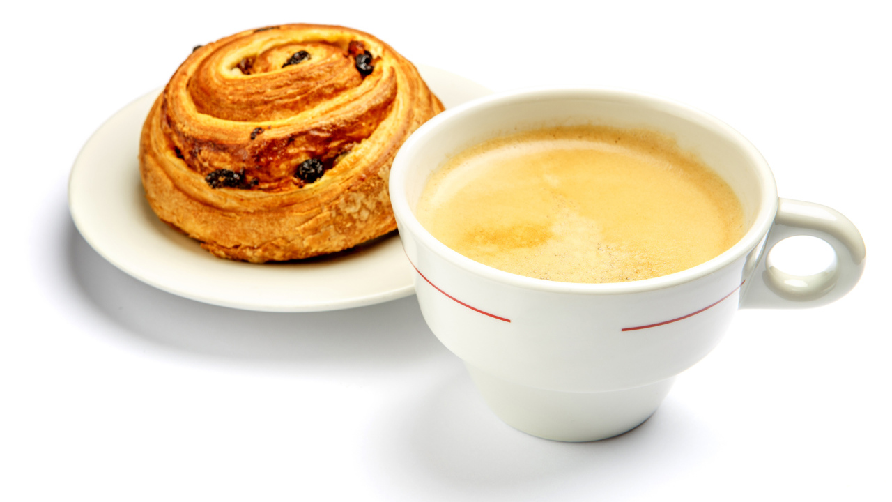 Чашка кофе с булочкой на столе