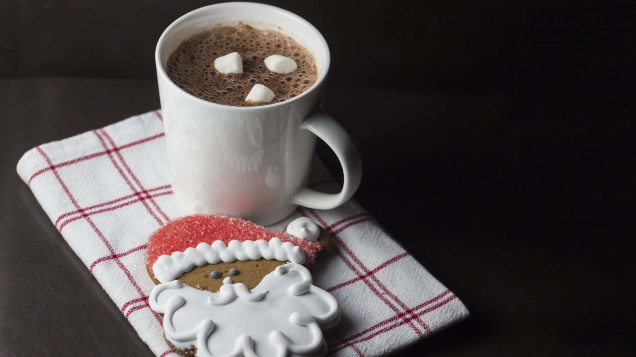 Чашка кофе с праздничным печеньем на черном фоне