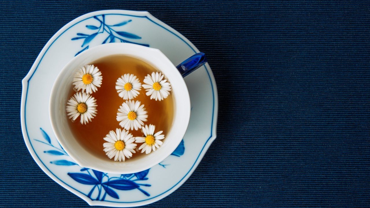 Чашка горячего чая с ромашкой на столе