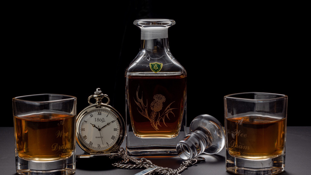 Дорогой коньяк на столе с карманными часами 