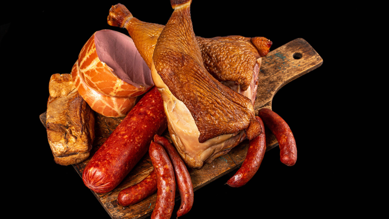 Appetizing smoked meats and sausage on a black background