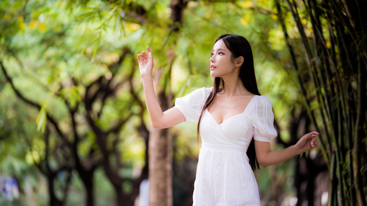 Девушка азиатка в белом платье у дерева