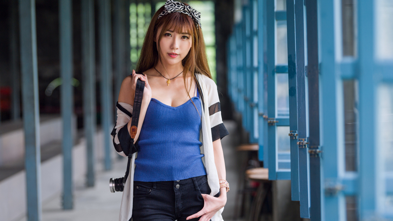 Девушка азиатка с фотоаппаратом в руках 