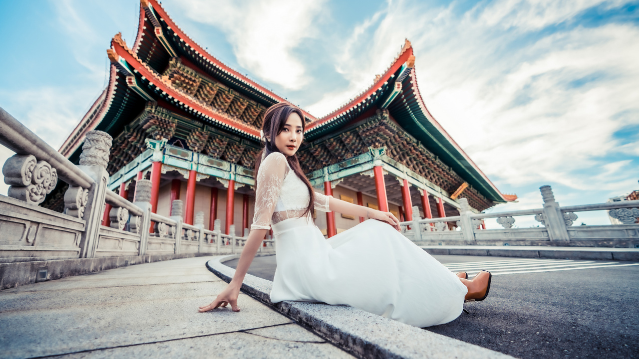 Красивая азиатка в белом платье на фоне храма