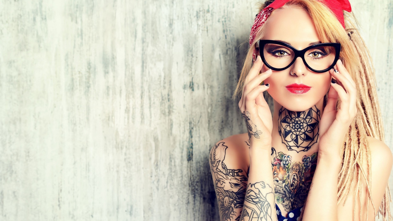 Красивая блондинка в очках с татуировками на теле