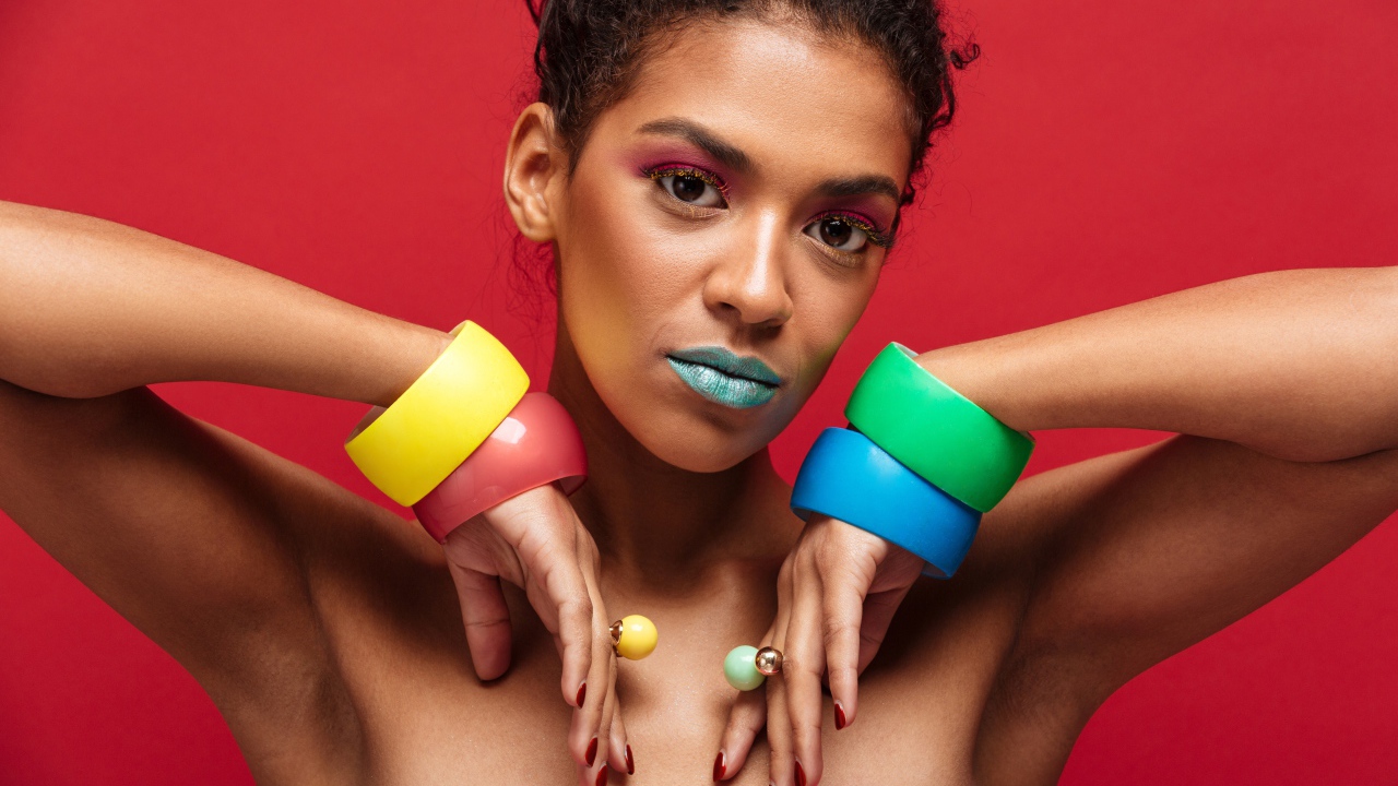 Красивая яркая девушка с разноцветными браслетами на руках