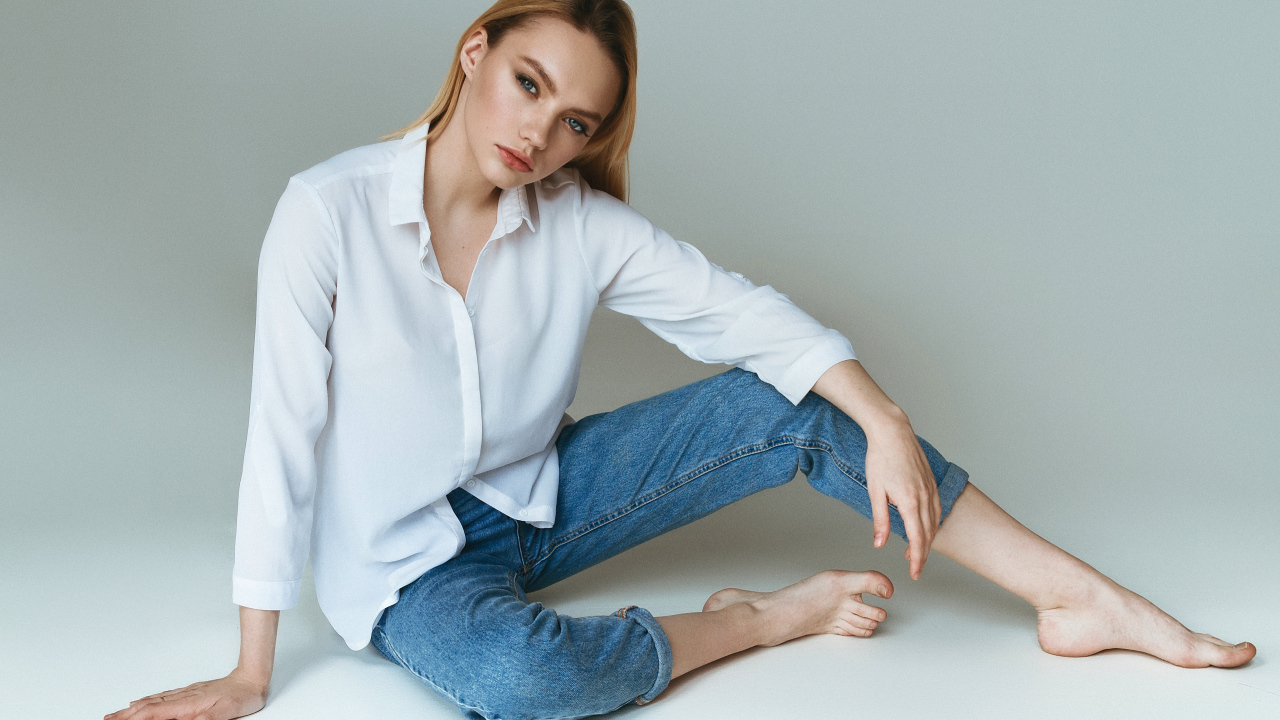 Красивая девушка в белой рубашке на сером фоне