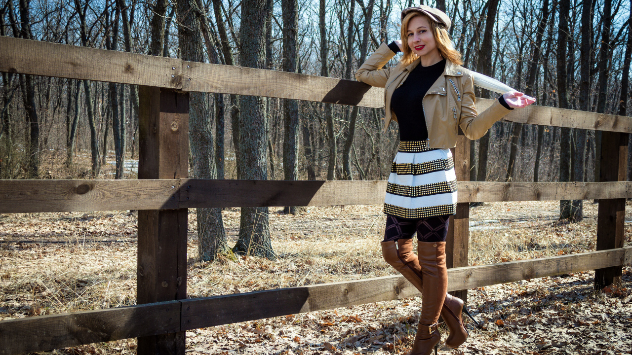 Красивая девушка стоит у забора на ферме