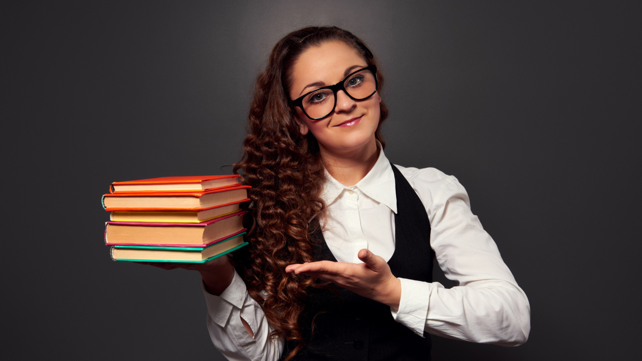 Красивая девушка учитель в очках с книгами в руке
