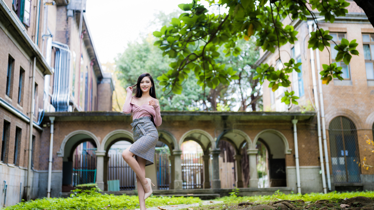 Красивая стройная азиатка на фоне здания