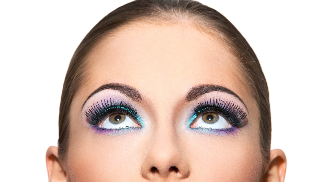 Яркий макияж на глазах у девушки на белом фоне