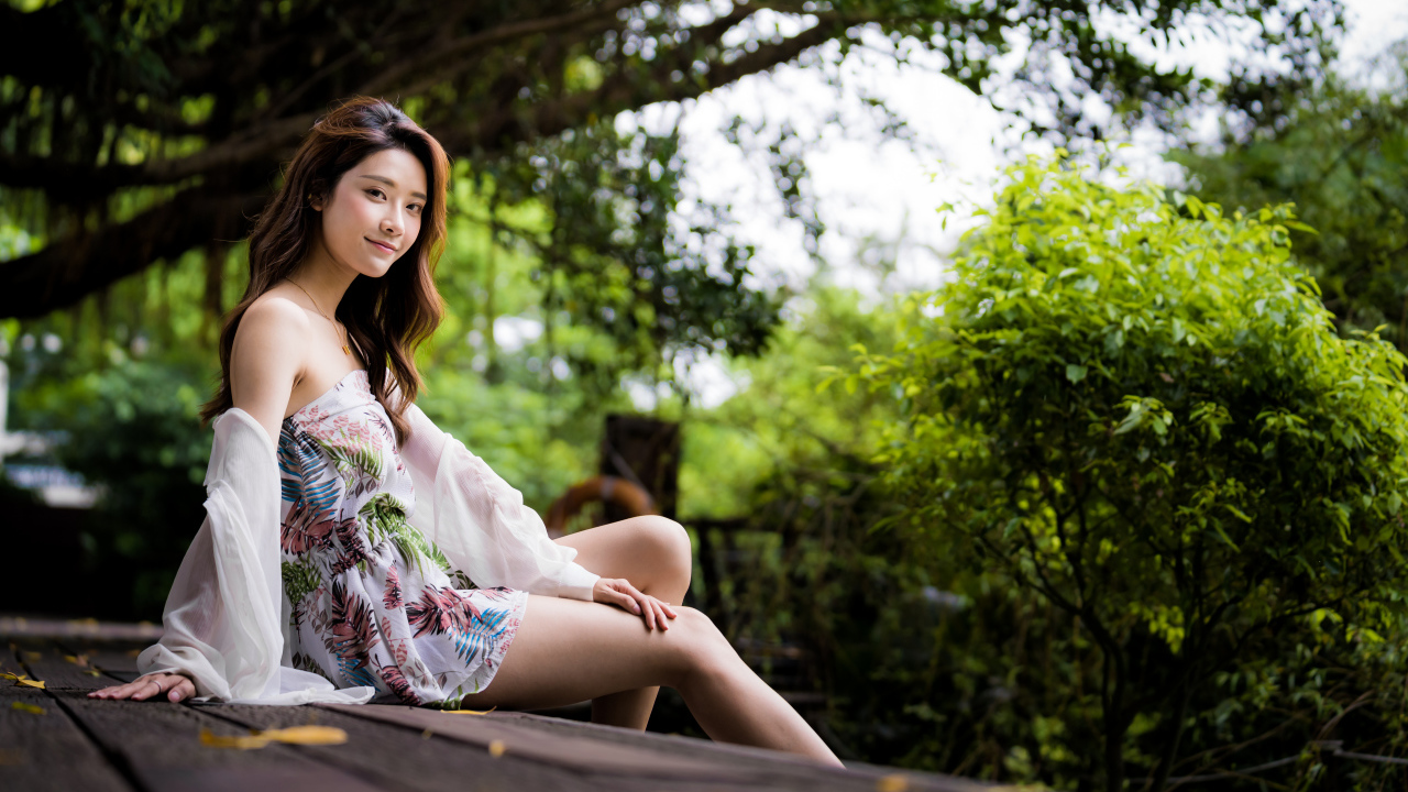 Милая девушка азиатка сидит на мосту