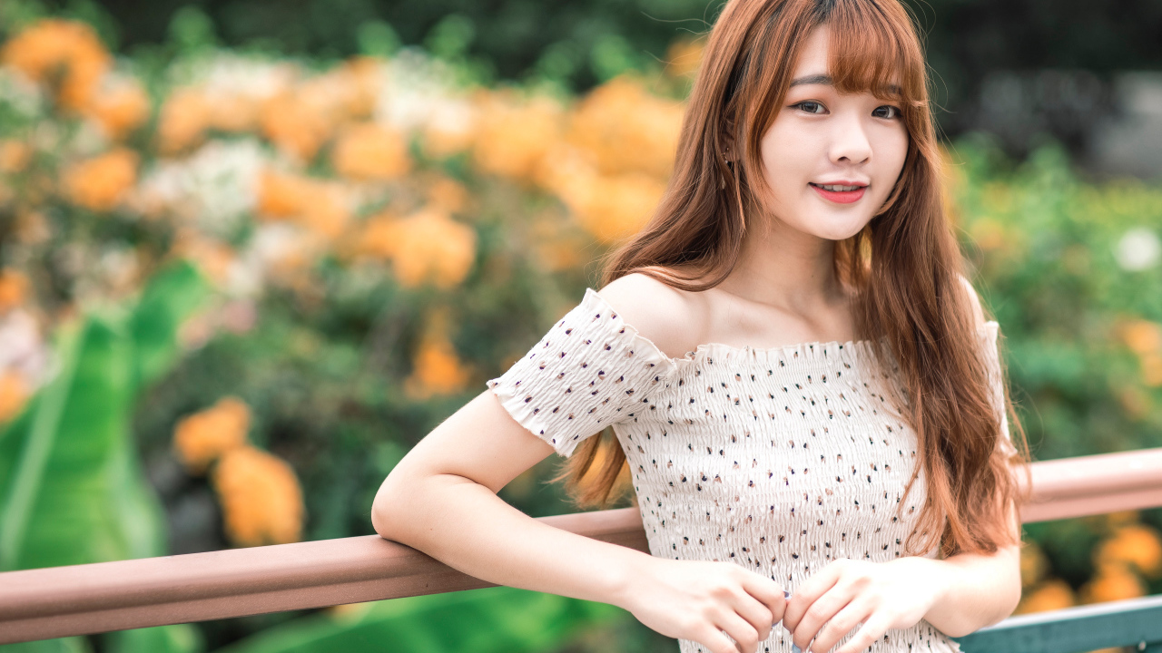 Милая девушка азиатка стоит у перил