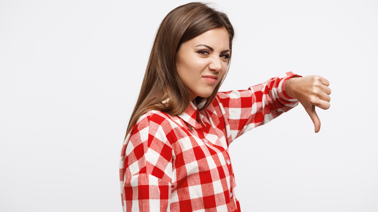 Недовольная девушка опустила палец вниз 