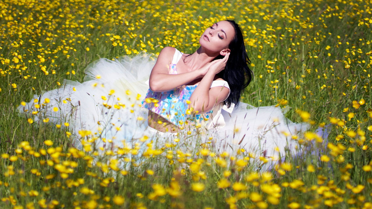 Девушка в красивом платье на траве с желтыми цветами