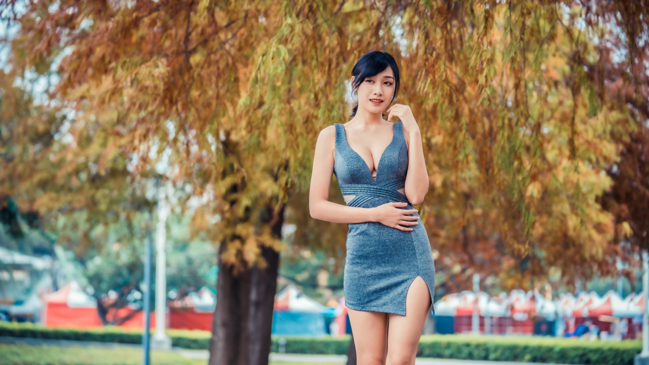 Девушка в сером коротком платье в осеннем парке