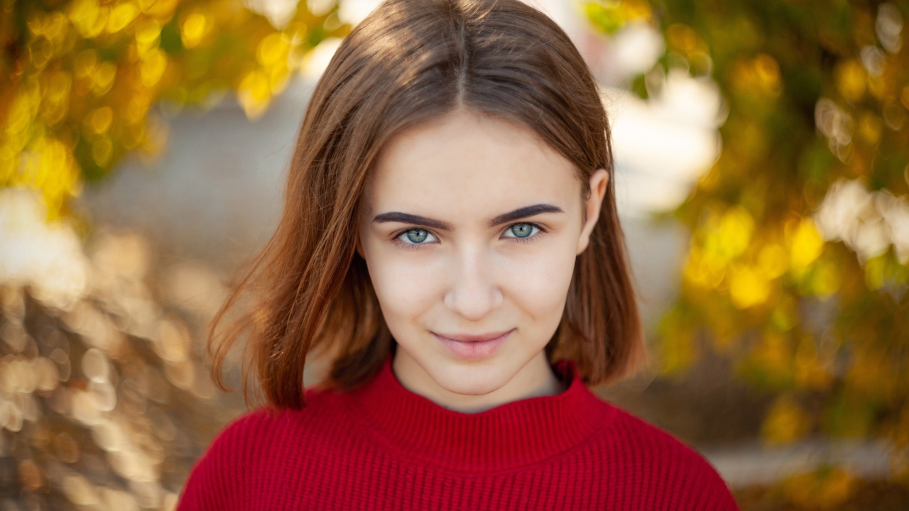 Девушка в красном свитере с короткой стрижкой 