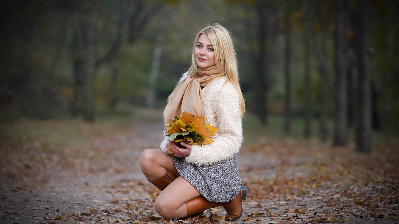 Девушка с листьями на дороге осенью