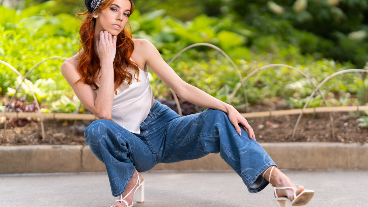 Рыжеволосая девушка в синих джинсах 