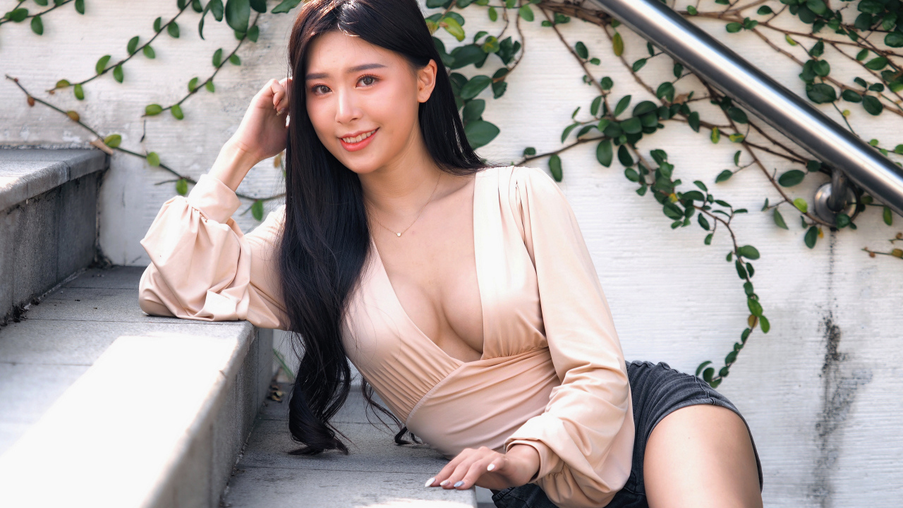 Улыбающаяся девушка азиатка с черными волосами на ступенях 