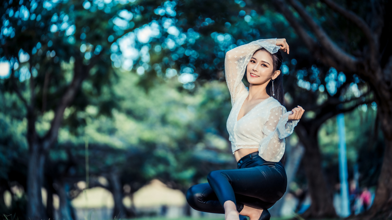 Улыбающаяся азиатка в черных брюках